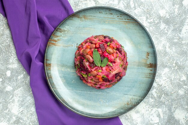 Top view vinaigrette beet potato salad on plate purple shawl on light table