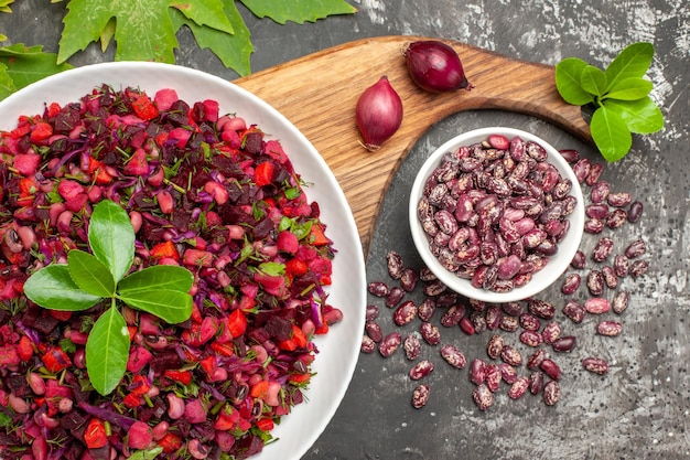 Top view vinaigrette salad with beet and beans on the grey surface