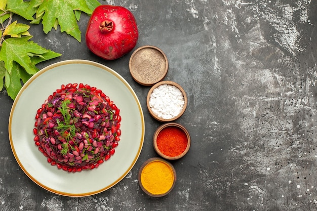 Top view vinaigrette salad with seasonings on dark surface