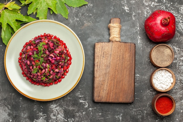 Top view vinaigrette salad with seasonings on the dark surface