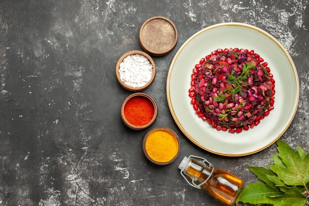 Top view vinaigrette salad with seasonings on the dark surface