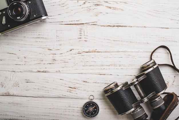 Top view of vintage camera, compass and binoculars