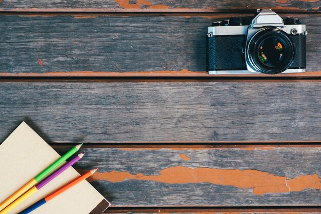 top view of vintage camera,notebook and colour pencil