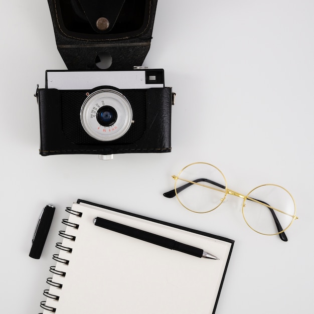 Top view vintage photo camera with a notepad