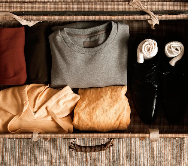 Вид сверху винтажный чемодан с повседневной одеждой