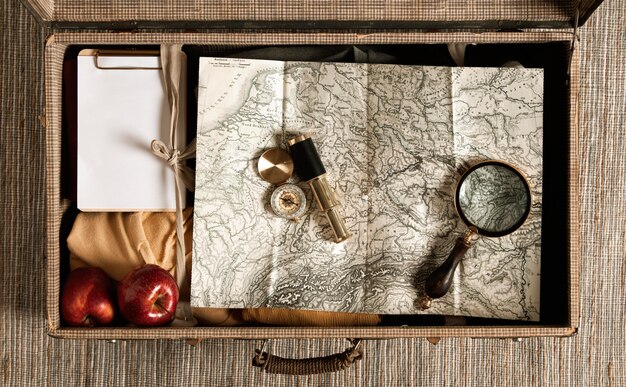 Top view vintage suitcase with map and magnifying glass