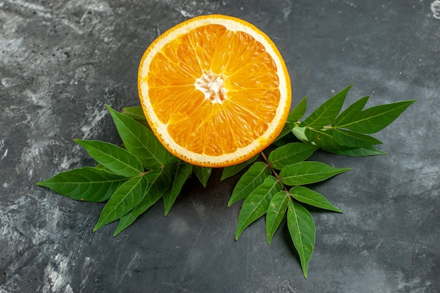 Free photo top view of vitamin source cut fresh orange with leaves on gray background