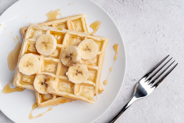 Top view of waffle with banana slices and honey