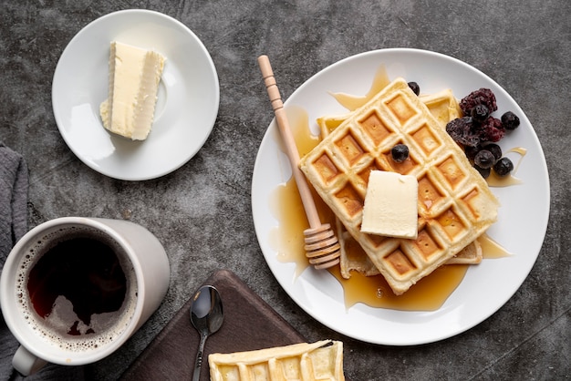 Free photo top view of waffles on plate with butter and cup of tea