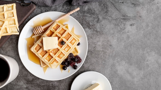 Top view of waffles on plate with butter and honey