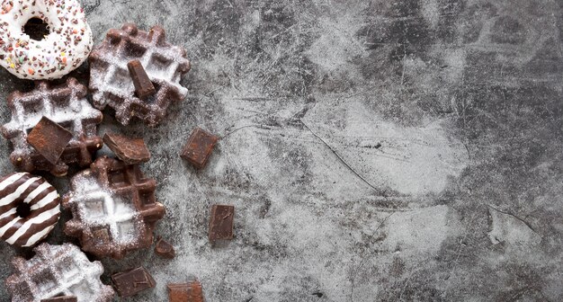 Foto gratuita vista dall'alto di cialde con cioccolato e ciambelle
