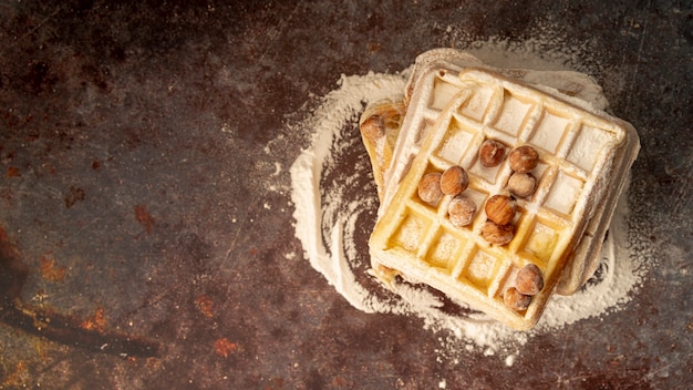 Top view of waffles with hazelnuts and powdered sugar
