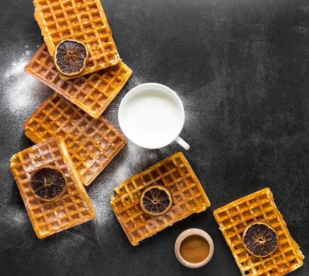 Free photo top view of waffles with milk and dried citrus