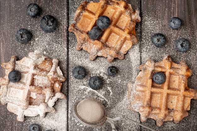 Free photo top view of waffles with powdered sugar and blueberries