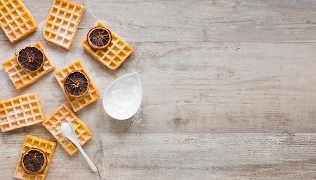 Top view of waffles with powdered sugar and dried citrus