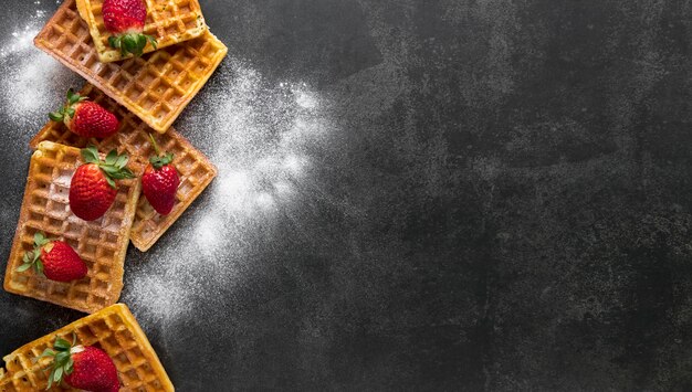 Top view of waffles with powdered sugar and strawberries