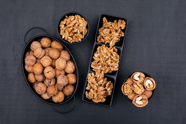 Free photo top view walnuts in black tableware on black  horizontal