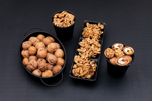 Top view walnuts in black tableware on black  horizontal