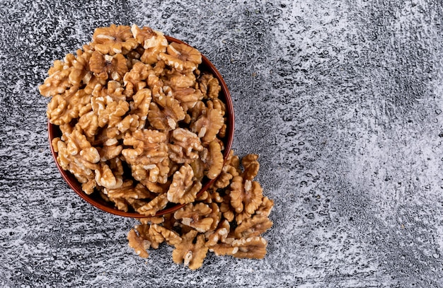 Free photo top view walnuts in bowl on stone  horizontal