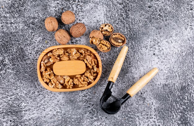 Вид сверху грецкие орехи в миску с Щелкунчиком на камне горизонтальной