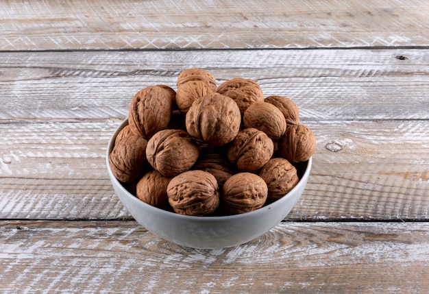 Top view walnuts in bowls on wooden  horizontal
