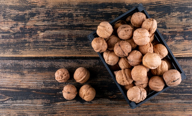 Top view walnuts in box on wooden  with copy space horizontal