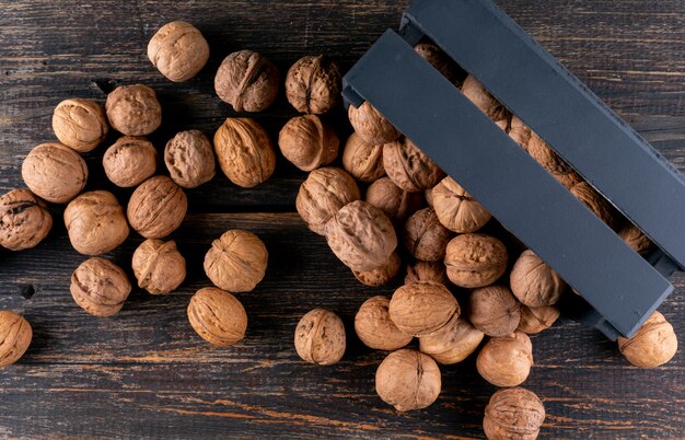 Top view walnuts from black box on wooden  horizontal