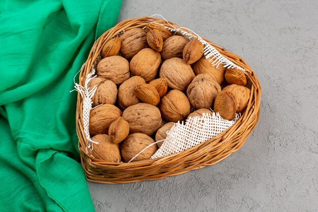 top view walnuts inside basket on the grey background