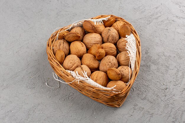 top view walnuts inside basket on the grey floor