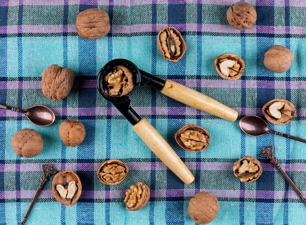 Top view walnuts and nutcracker on table cloth horizontal