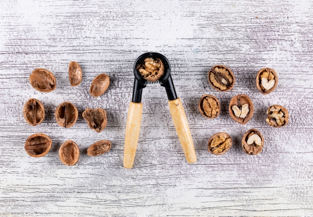 Free photo top view walnuts and nutcracker on wooden  horizontal