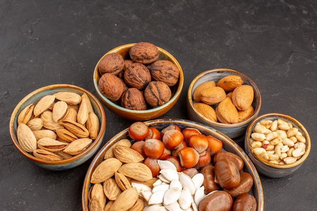 Top view of walnuts, peanuts, and other nuts on a dark surface