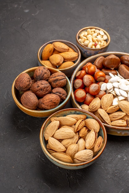 Top view of walnuts, peanuts, and other nuts on dark surface