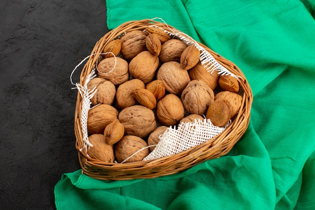 top view walnuts whole inside basket on the dark background