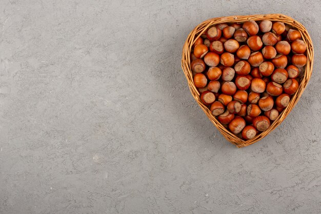 top view walnuts whole inside basket on the grey floor