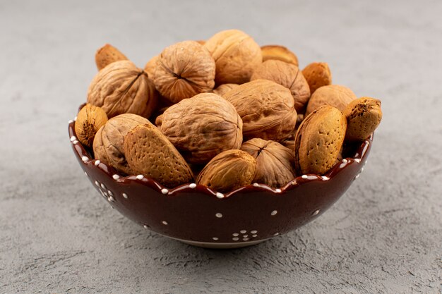 top view walnuts whole inside plate on the grey floor