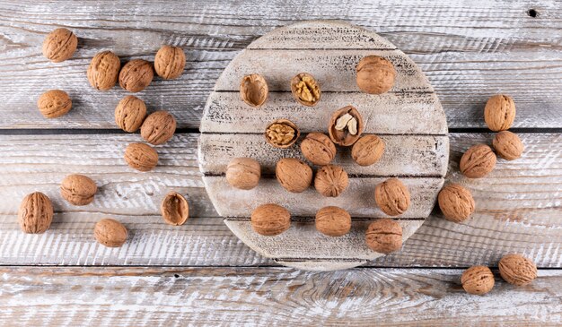 Top view walnuts on wooden cutting board on wooden  horizontal