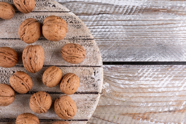 Top view walnuts on wooden cutting board on wooden  horizontal