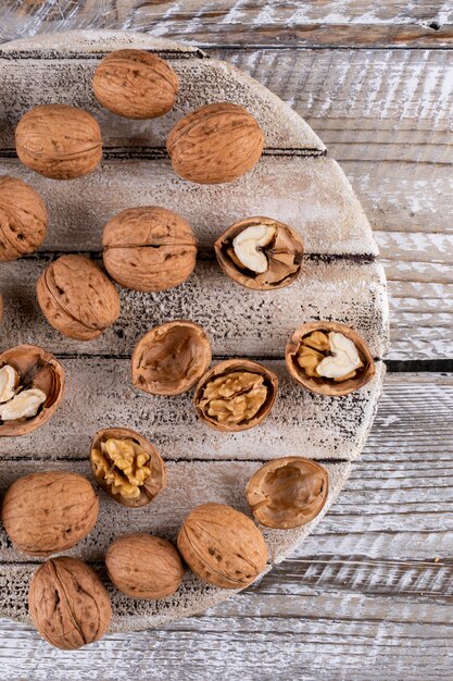 Top view walnuts on wooden cutting board on wooden  vertical