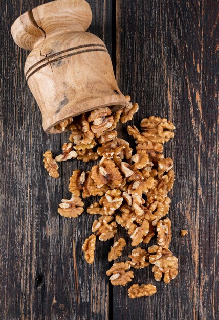 Top view walnuts in wooden mortar on wooden  vertical