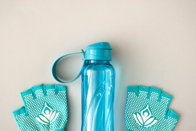 Top view water bottle and gloves