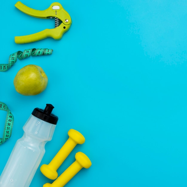 Top view of water bottle with measuring tape and apple