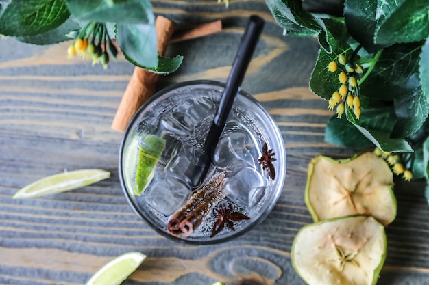 Top view water in a glass with cinnamon lime and dried apple wedges