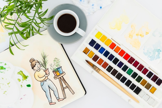 Free photo top view watercolors with cup of coffee