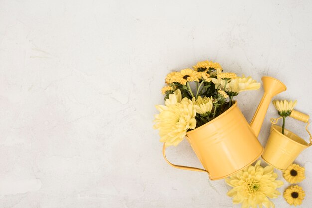 Top view watering can with yellow flowers