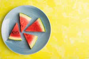 Free photo top view of watermelon slices inside blue plate on the yellow surface