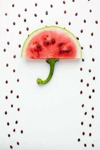 Top view watermelon umbrella with seeds on white background