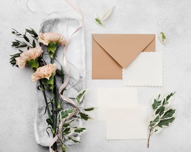 Вид сверху на свадебные пригласительные конверты с цветами