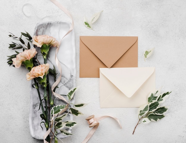 Top view wedding invitations with flowers on the table