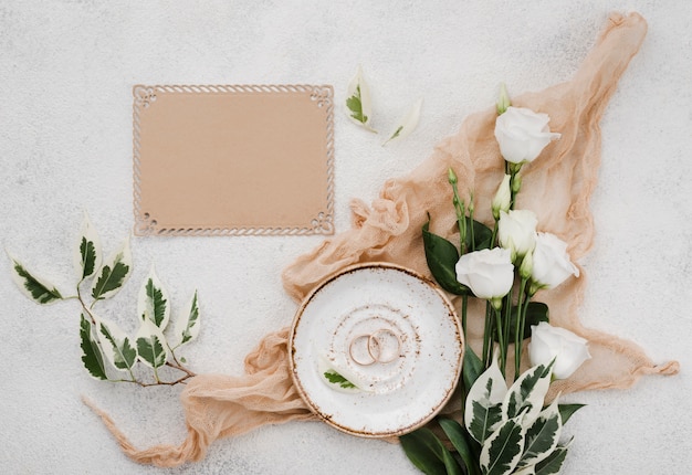 Top view wedding rings with flowers on the table